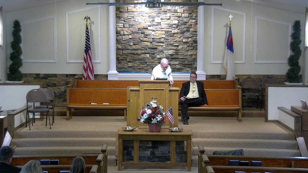 The auditorium at Countryside Baptist Church seen from the back pews, with the communion table in the foreground reading 'This do in remembrance of me'.